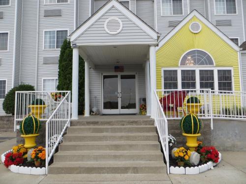 a yellow and white house with stairs and flowers at Patti's Inn and Suites in Grand Rivers