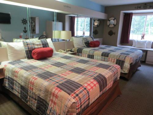 um quarto de hotel com duas camas e uma sala de estar em Patti's Inn and Suites em Grand Rivers