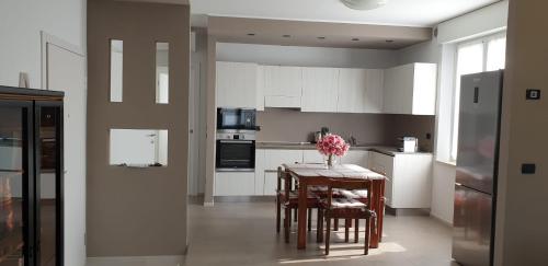 een keuken met een tafel en stoelen en een keuken met witte kasten bij Appartamento ROSY in Peschiera del Garda