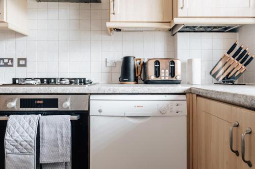 a kitchen with a stove and a dishwasher at Top quality beach front apartment sleep up to 7 guests in Bournemouth