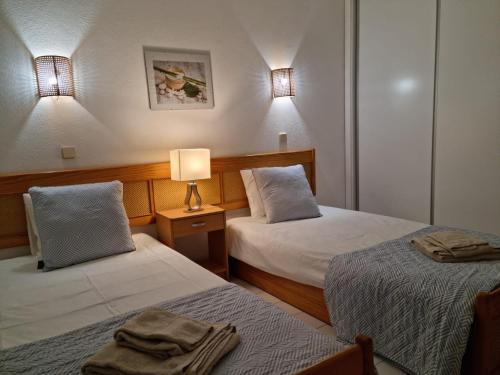 een hotelkamer met 2 bedden en een lamp bij Velamar Praia 411 - 300m da praia in Albufeira