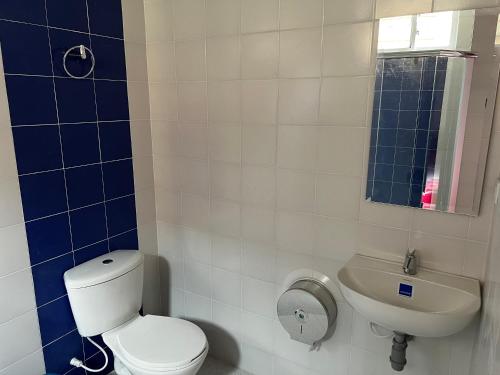 a bathroom with a toilet and a sink at Hospedaje Lycaste in Tibasosa