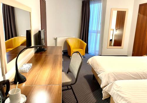 a hotel room with a desk with a television and a bed at Poleczki Residence Apartments in Warsaw