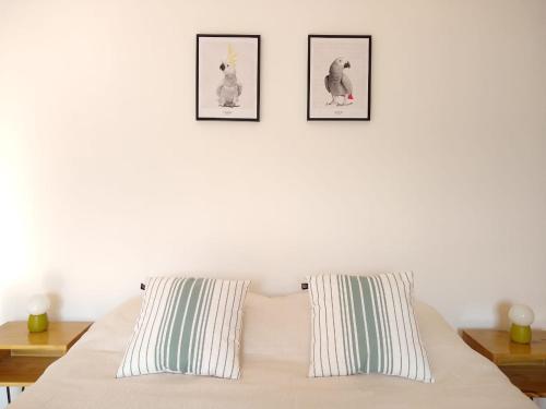 Buenaventura Apartment في ميندوزا: غرفة نوم بسرير بثلاث صور على الحائط