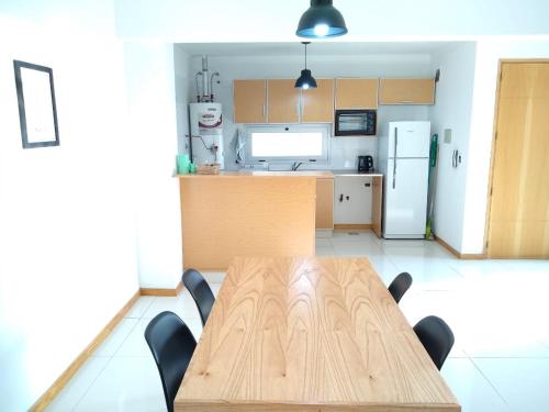 a kitchen with a wooden table and a refrigerator at Buenaventura Apartment in Mendoza