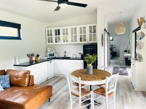 a kitchen and living room with a table and a couch at Farm Stay MAPLE Cottage at Wilindi Estate in Tyabb