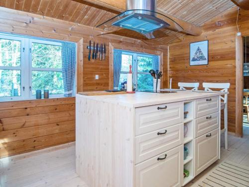 a kitchen in a log cabin with a large island at Holiday home Kolind VI in Kolind