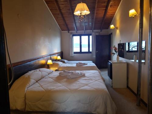 um quarto com 2 camas e um lustre em Tango B&B em Ushuaia