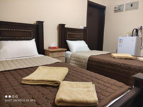 a hotel room with two beds with towels on them at Majido Hotel in Wadi Musa