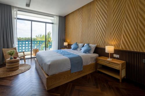 a bedroom with a large bed and a large window at The Stay Saigon Riverfront in Gò Công