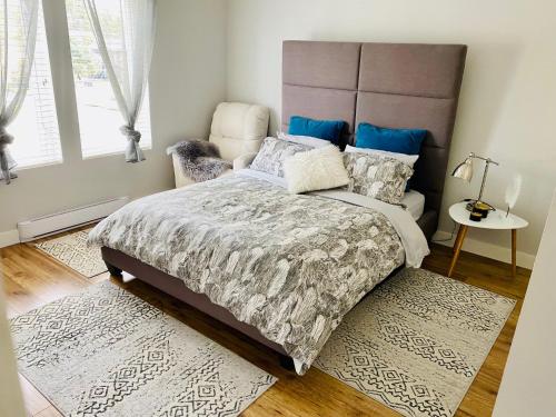 1 dormitorio con 1 cama grande y 1 silla en Cozy suite close to Nature and the City en Maple Ridge District Municipality