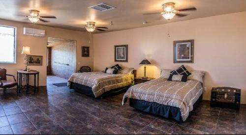 a hotel room with two beds and a table at Turtle Back Mesa Bed and Breakfast in Indio