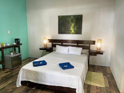 a bedroom with a bed with two blue towels on it at Casa turtle Bogue in Tortuguero