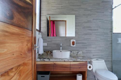 a bathroom with a sink and a toilet and a mirror at Cougar Monteverde in Monteverde Costa Rica