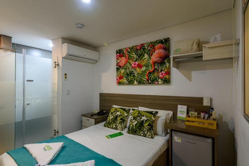 a bedroom with a bed and a painting on the wall at Lleras Green Hotel in Medellín