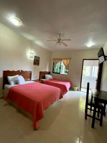 a bedroom with two beds and a table in it at Hotel Santa Isabel in Ciudad del Carmen
