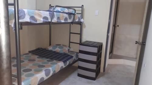 1 Schlafzimmer mit 2 Etagenbetten und einer Leiter in der Unterkunft Apartamento Familiar frente a la Playa in Playas