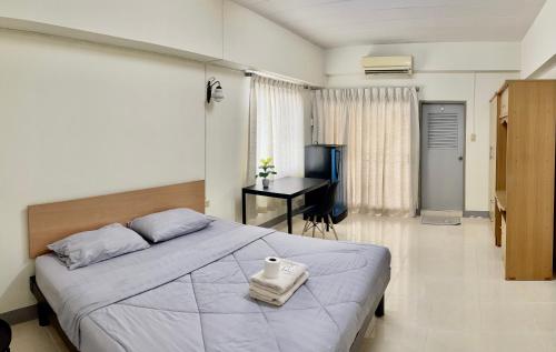 1 dormitorio con 1 cama grande y escritorio en Grand Residence, en Bangkok