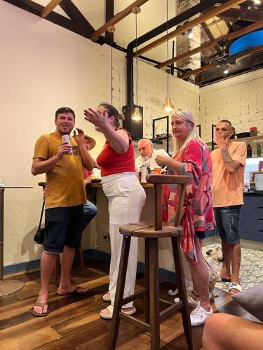 a group of people standing in a kitchen with a microphone at Hostel El Caminito LGBTQIAPN plus in Santos