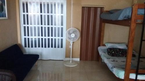 a room with a fan and a bunk bed at Suite frente a la playa in Playas