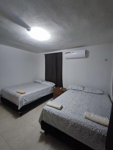 a bedroom with two beds and a light on the ceiling at Cancun Property 6 personas in Cancún