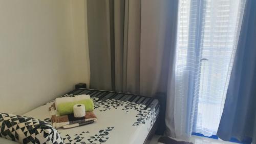 a small bed in a room with a window at Sea Residences TowerE-F by EZStays in Manila
