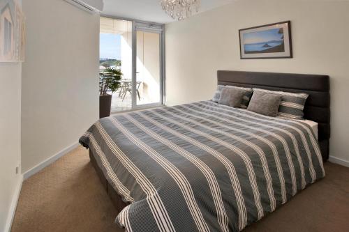 1 dormitorio con 1 cama grande y ventana grande en Harbour Views en Lakes Entrance