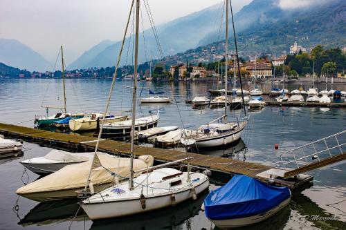 a group of boats docked at a dock in the water at Le Petit Palais Villa in Plesio