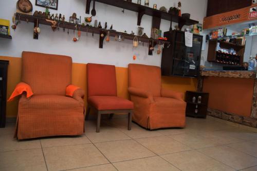 two orange chairs sitting next to a counter in a store at Kali Huasteca Posada in Ciudad Valles