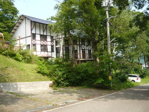 a white house on the side of a street at Chalet Myoko in Myoko