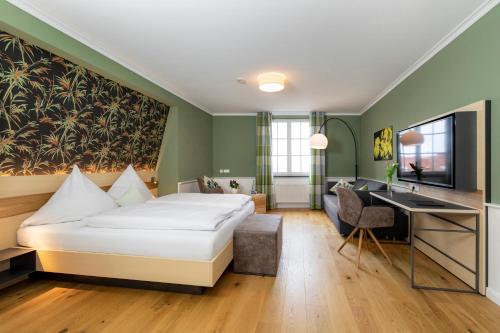 a hotel room with a bed and a desk at Hotel Der Löwen in Hagnau