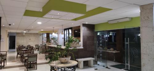 a restaurant with green walls and tables and chairs at Hotel Dubrovnik in Mérida