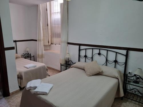 1 dormitorio con 2 camas y toallas. en Pensión Javier en Sevilla