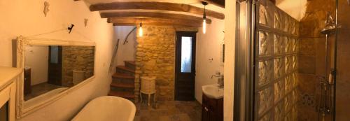 a bathroom with a toilet and a sink and a mirror at casa de piedra.The stone house in Turre