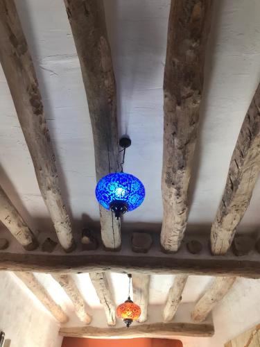two lights hanging from the ceiling of a building at casa de piedra.The stone house in Turre