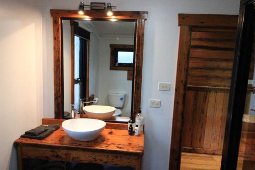 a bathroom with two sinks and a large mirror at The Cottage in Bairnsdale