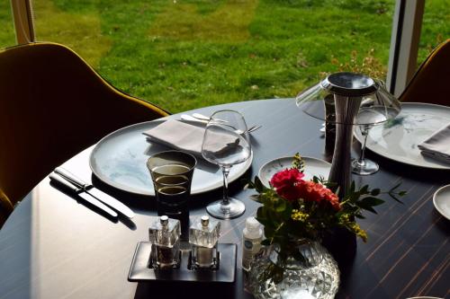 a table with plates and glasses and a vase of flowers at Chateau du Clos de la Ribaudiere - Teritoria in Chasseneuil-du-Poitou