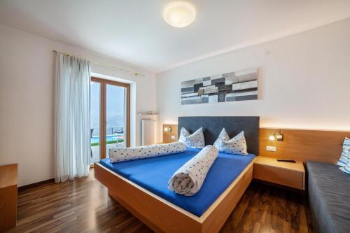 um quarto com uma cama azul e uma grande janela em Haus Hohenrain Ferienwohnung 2 em Scena