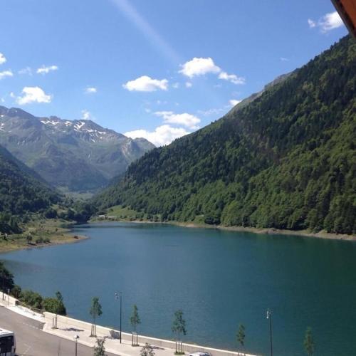 a view of a lake in the middle of a mountain at Appartement sur le bord du lac de fabreges in Laruns