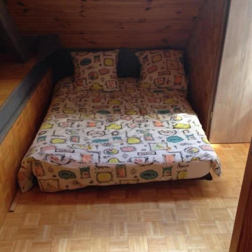 małe łóżko w pokoju z drewnianą podłogą w obiekcie Appartement sur le bord du lac de fabreges w mieście Laruns