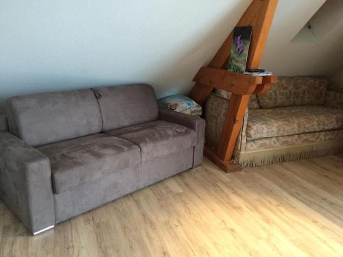 sala de estar con sofá y silla en Appartement sur le bord du lac de fabreges, en Laruns