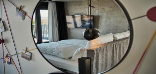 a mirror reflecting a bed in a bedroom at Urban Nature St Peter-Ording in Sankt Peter-Ording