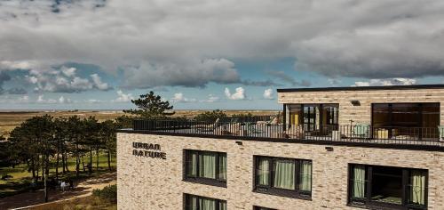 a building with a balcony on top of it at Urban Nature St Peter-Ording in Sankt Peter-Ording