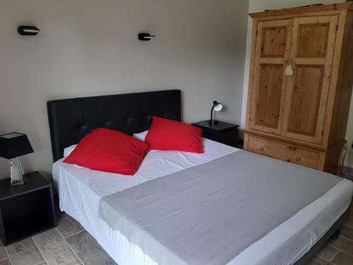a bedroom with a large bed with red pillows at Logis des Magnans -Les terrasses du Coutach - in Sauve