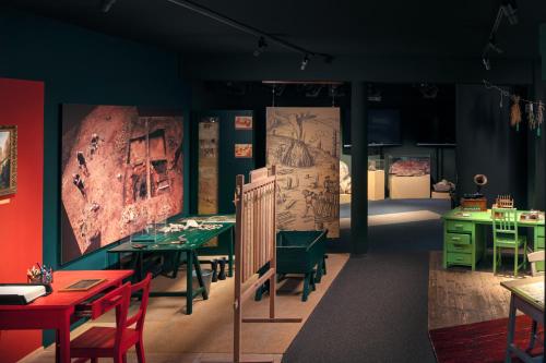 a dining room with tables and chairs and paintings on the walls at Apartmán - Dům Českého Švýcarska in Krásná Lípa