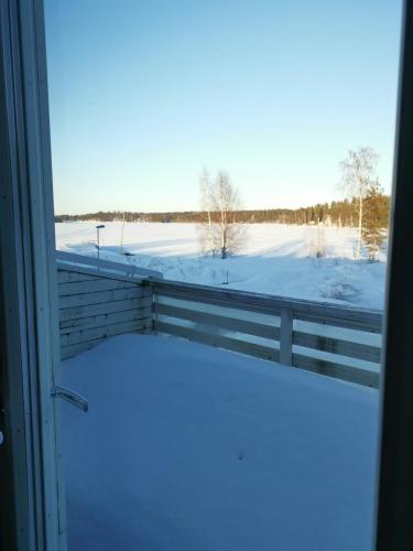 a view of a snow covered field from a window at Saimaa Seasons Marina Villas in Imatra