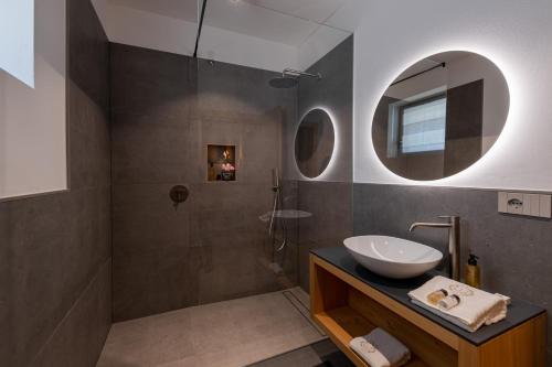 a bathroom with a sink and a shower with a mirror at SHILOH Private Luxury Apartments in Costermano sul Garda