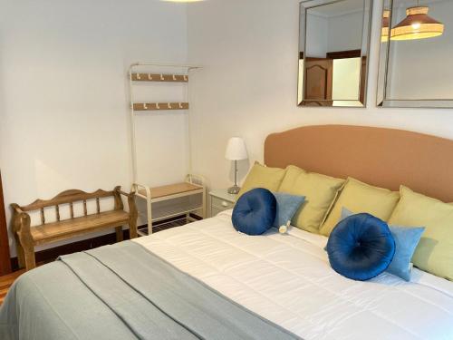 a bedroom with a bed with blue pillows on it at Amplio y Elegante en Las Arenas in Getxo