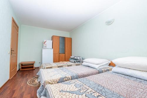 a room with two beds and a refrigerator at Elektromash Hotel in Tiraspol