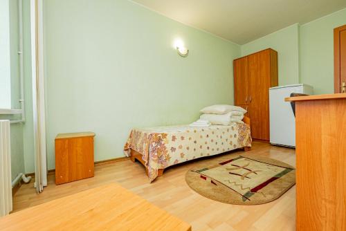 a small bedroom with a bed and a rug at Elektromash Hotel in Tiraspol